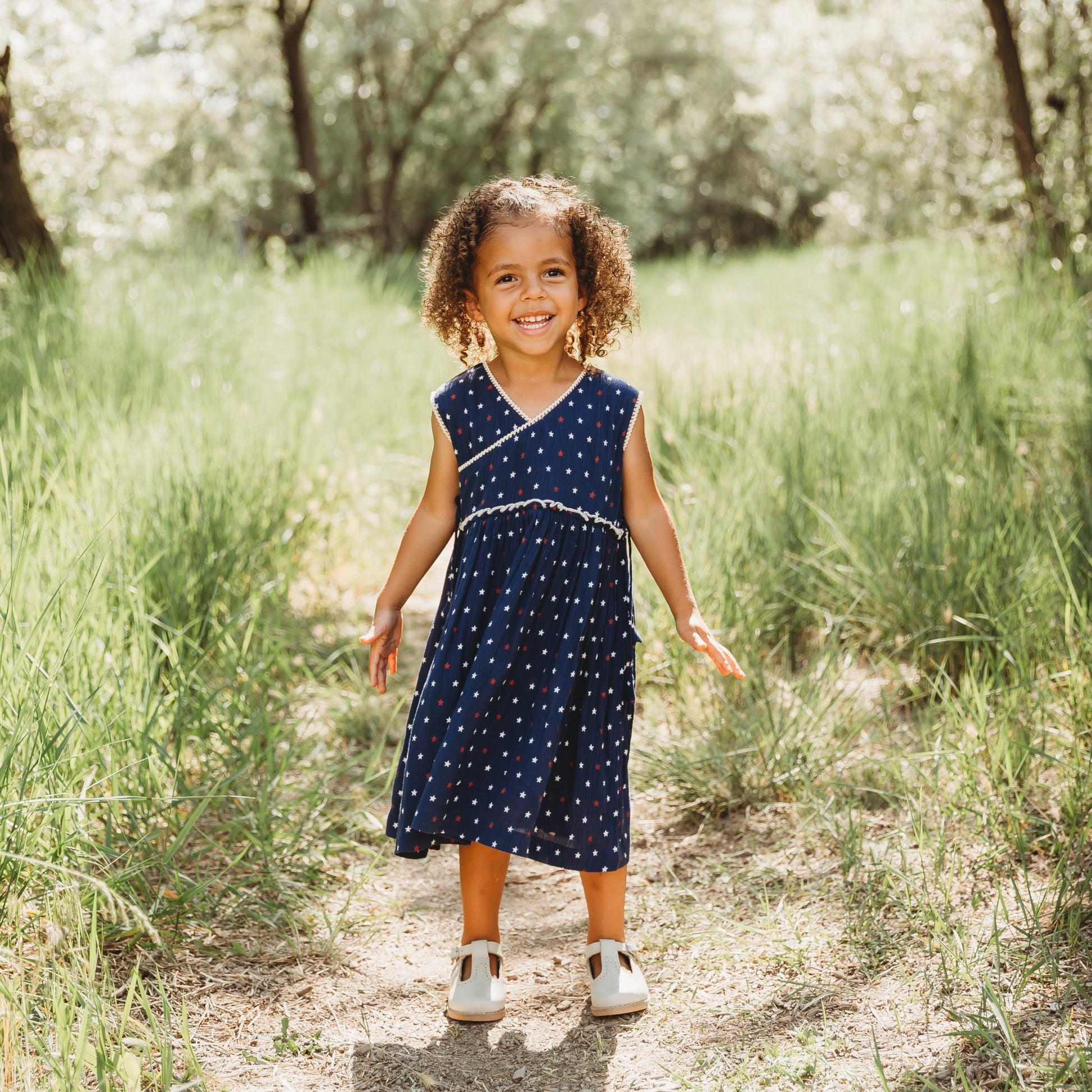 A 3-year-old model showing the Blue Stars 4th of July Dress - LARILI