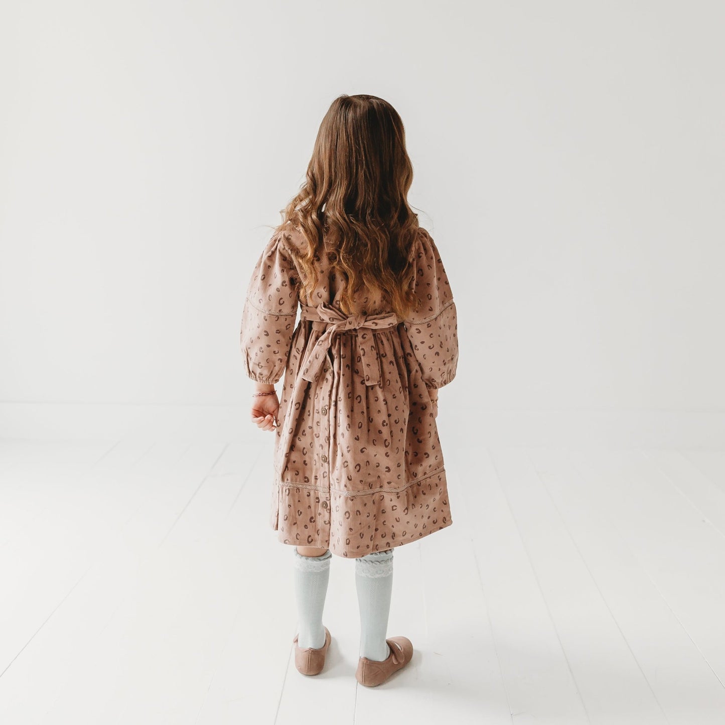 Back view 5-year-old girl in LARILI Cord Crush dress. Lavender animal print corduroy with lace collar and handmade details.