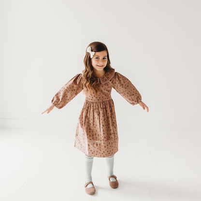 5-year-old girl posing in LARILI Cord Crush dress. Lavender animal print corduroy with lace collar and handmade details.