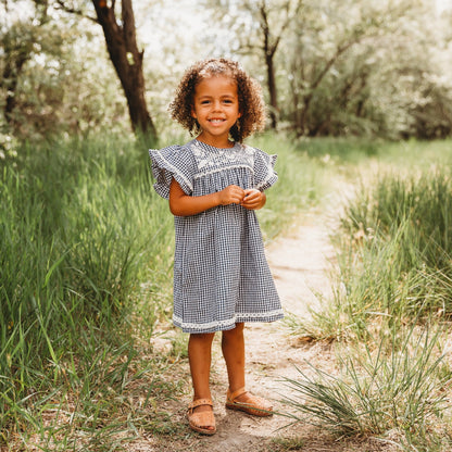 A 5-year-old model showing the Embroidered Yoke Eith Ruffle Sleeves Dress - LARILI