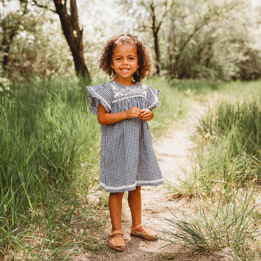 A 5-year-old model showing the Embroidered Yoke Eith Ruffle Sleeves Dress - LARILI