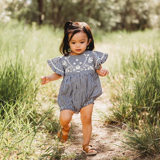 A 2-year-old model showing the Embroidered Yoke Eith Ruffle Sleeves Romper - LARILI