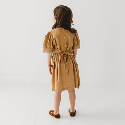 A 5-year-old model showing the back view of Embroidered yoke with Puff Sleeves - LARILI