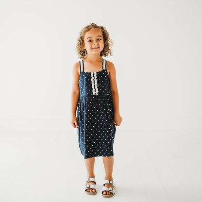 5-year-old girl in LARILI nautical blue polka dot cotton dress. 100% cotton with lace straps.