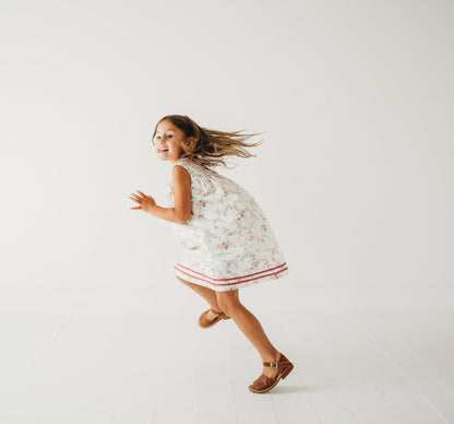 5-year-old girl in LARILI Victorian Rosebud dress. Pink floral cotton with lace V-neck and vintage button back.