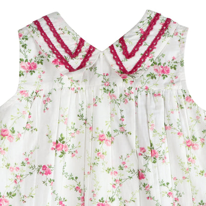 Close up of LARILI Victorian Rosebud dress. Pink floral cotton with lace V-neck and vintage button back.