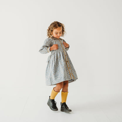 Young girl modeling the Whispering Florals grey cotton dress with Peter Pan collar.