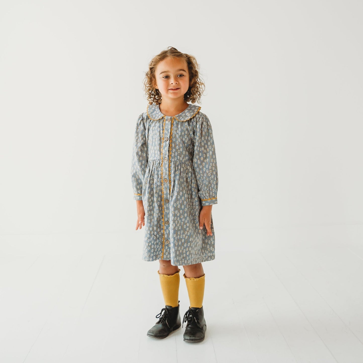 Young girl modeling the Whispering Florals grey cotton dress with Peter Pan collar.