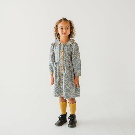 Young girl modeling the Whispering Florals grey cotton dress with Peter Pan collar.