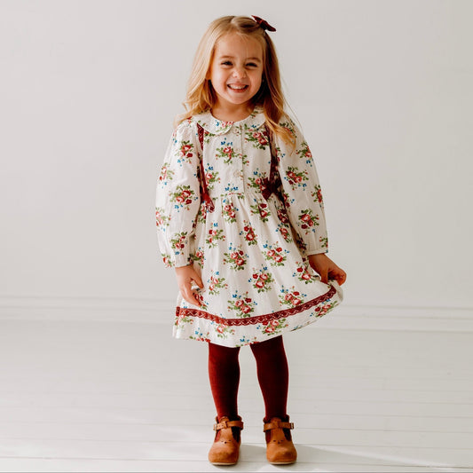 A 3-year-old model showing the Bunch Floral Printed Girl's Cotton Dress with Crimson Lace - LARILI